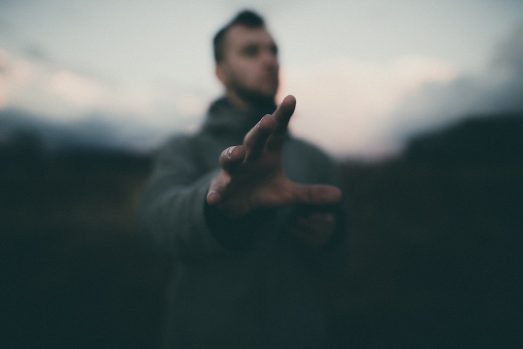 blurred image of a man reaching out his hand