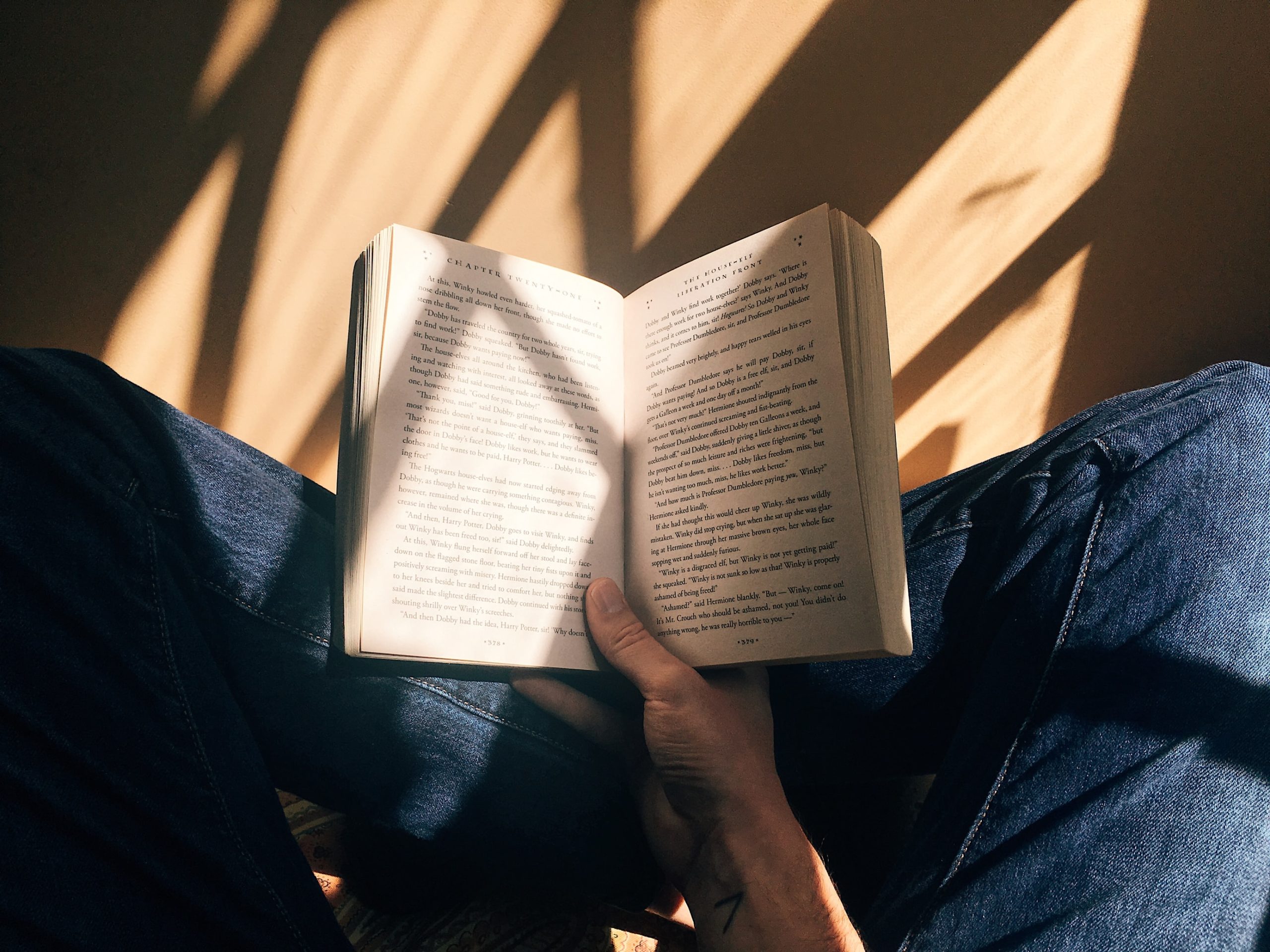 person holding a book open in their lap